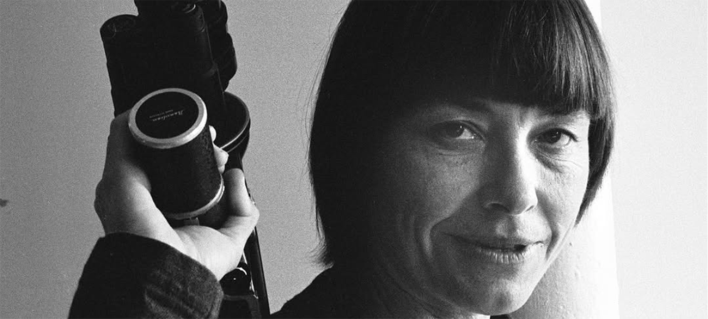 Barbara Hammer holding a camera over her shoulder
