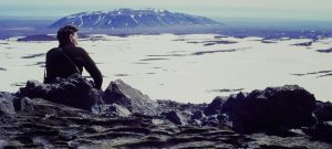 A person sits overlooking a glacier